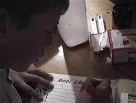 Daniel tries the calligraphy set bought from Machynlleth the day before yesterday, a fine thing to do at Tyncornel, the remotest hostel in England and Wales